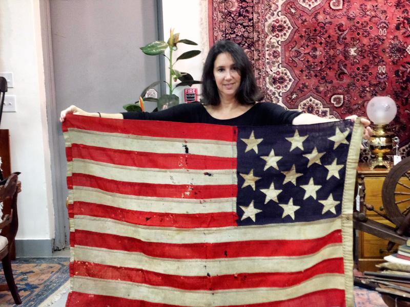 Mauria Stein of Stuart Kingston Gallery shows off an American flag with 13 stars that was part of a 2014 family estate auction. FILE PHOTO